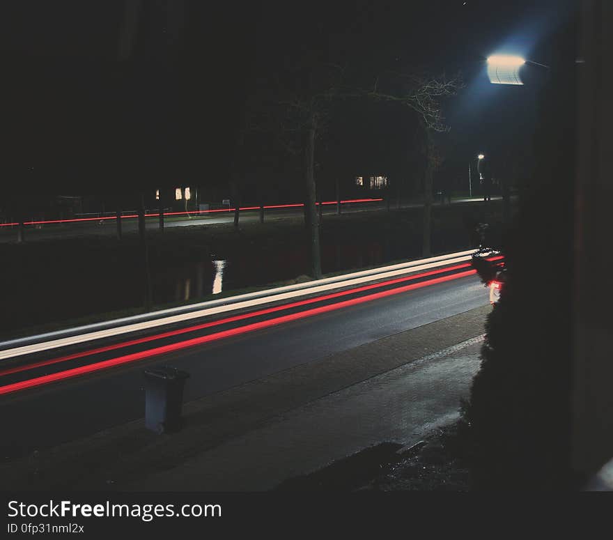 A long exposure of a street with light streaks from car lights at night.