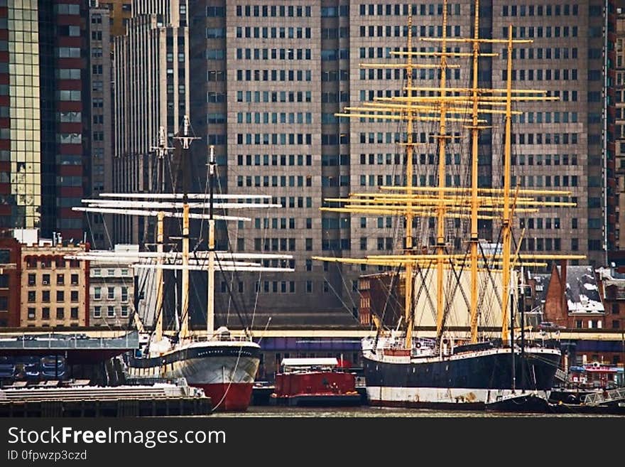 Black White and Yellow Boat Beside Gray Red and White Boat