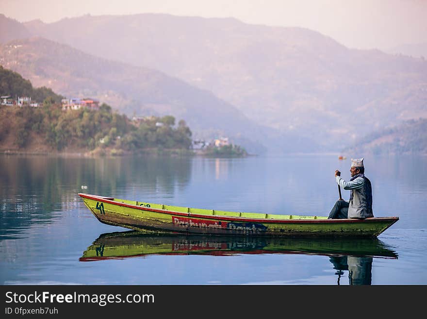 An old fisherman in a boat on a lake. An old fisherman in a boat on a lake.