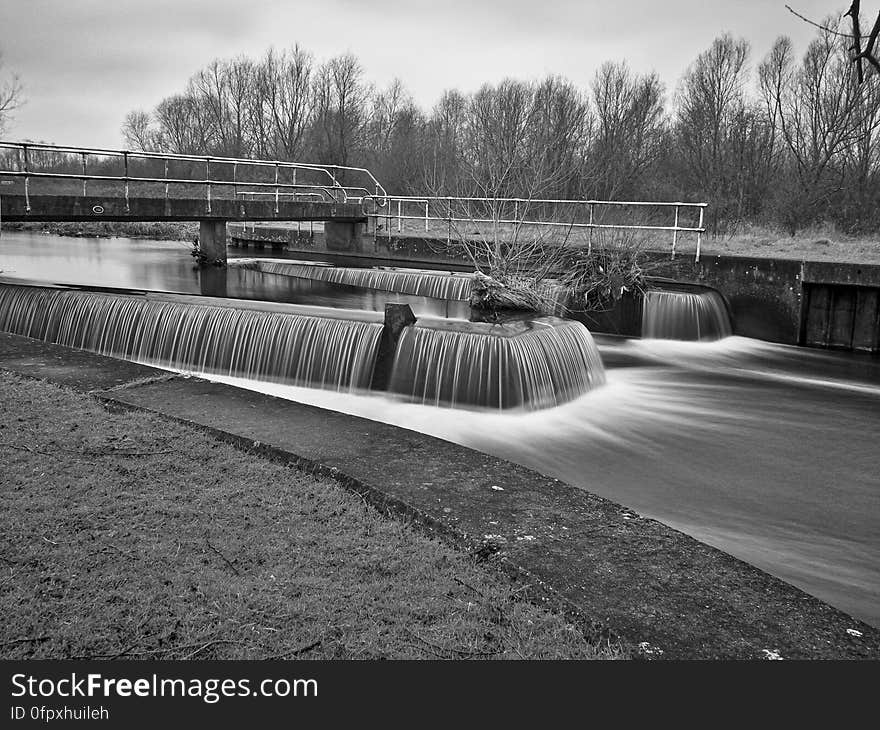 A black and white photo of a river with a weir. A black and white photo of a river with a weir.