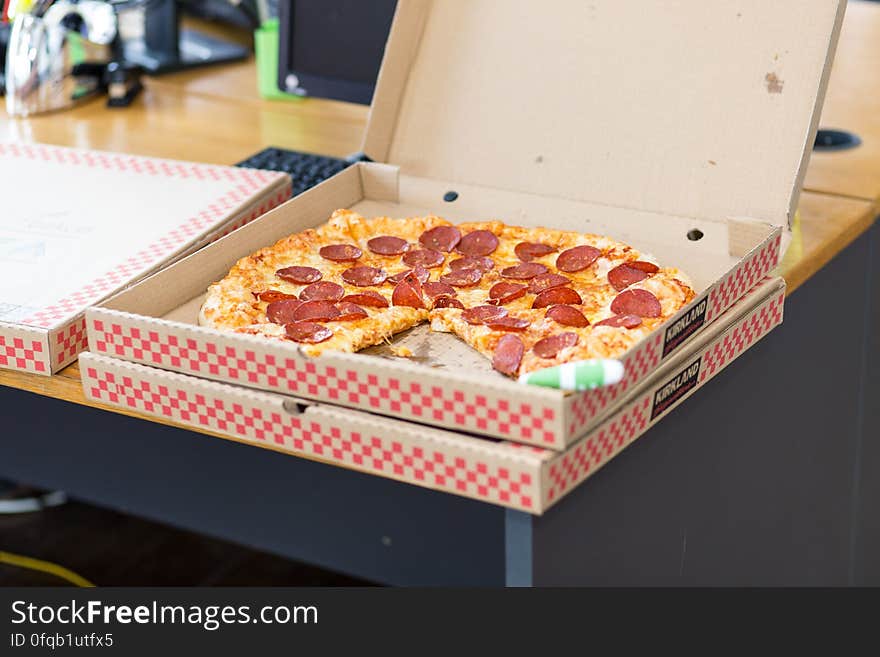 A pizza box with salami or pepperoni pizza on the table. A pizza box with salami or pepperoni pizza on the table.