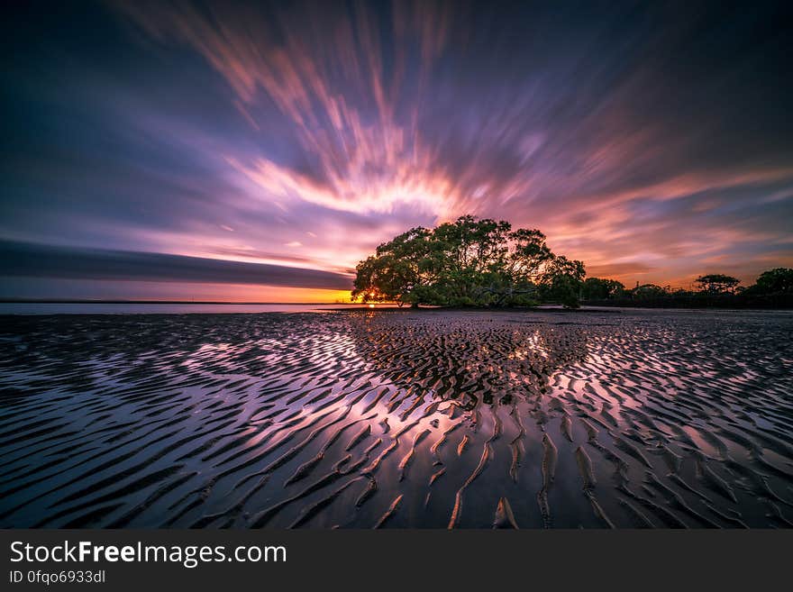 A sandy beach with low tide at sunset. A sandy beach with low tide at sunset.