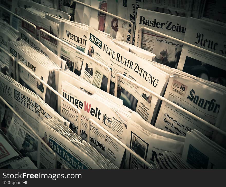 A news stand with various newspapers for sale. A news stand with various newspapers for sale.