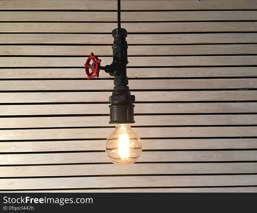 A close up of a hanging light bulb with a valve. A close up of a hanging light bulb with a valve.