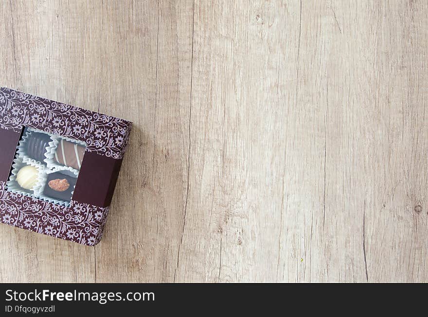 A box of chocolates on wood background.