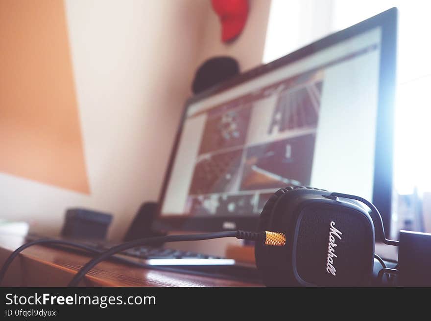 A desk with a desktop computer and a pair of headphones. A desk with a desktop computer and a pair of headphones.