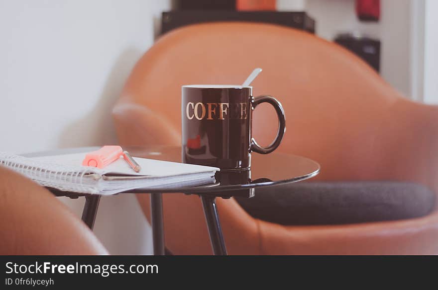 Brown and White Drinking Mug on the Top of Round Glass Top Table