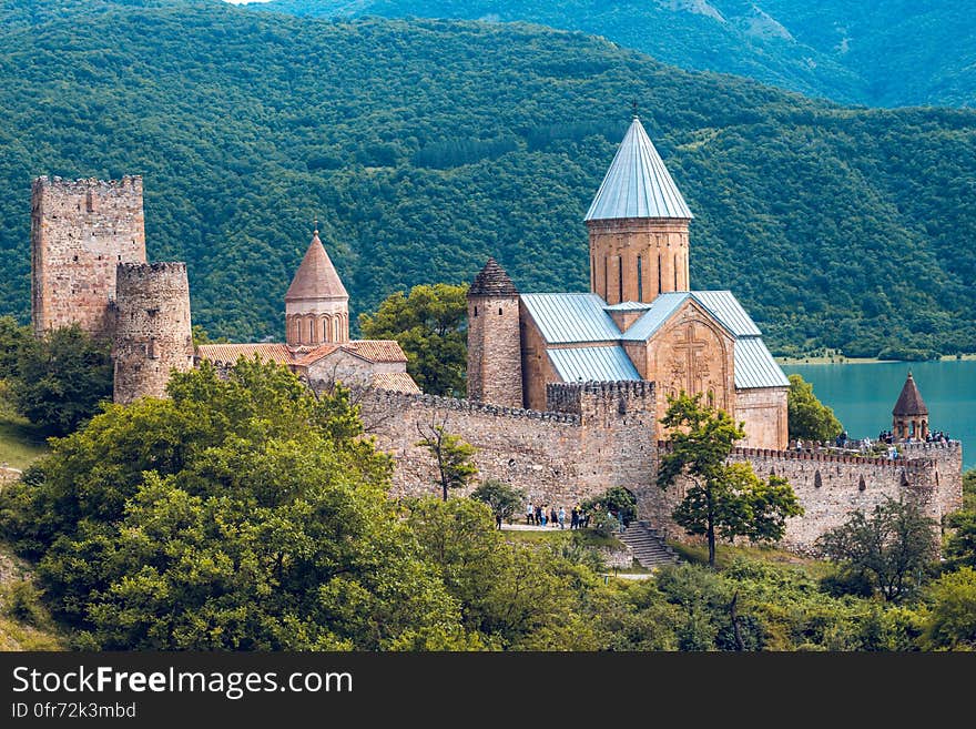 Scenic view of medieval castle on forested coastline. Scenic view of medieval castle on forested coastline.