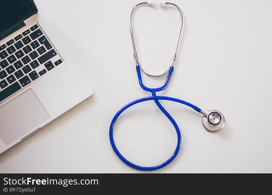 A laptop with a stethoscope next to it. A laptop with a stethoscope next to it.