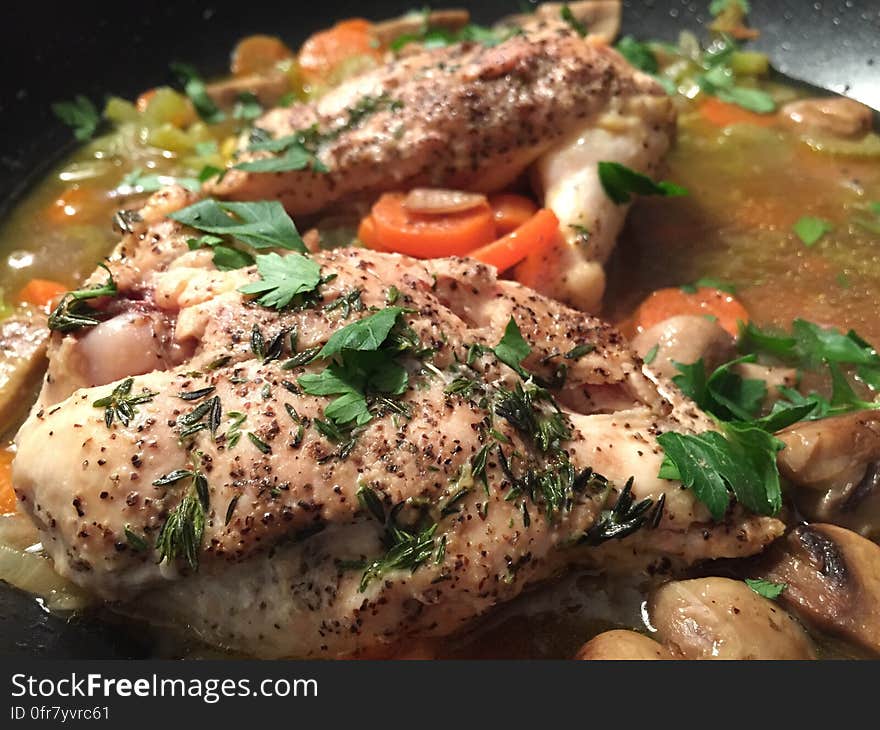 A close up of roast chicken with spices in a saucepan.