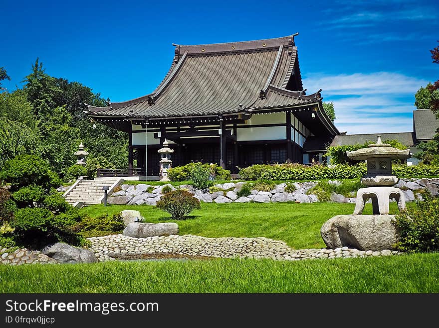 White and Black Temple Surrounded by Green Grass Field during Daytime