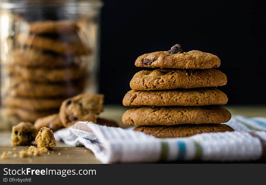 A close up of chocolate chip cookies piled up.