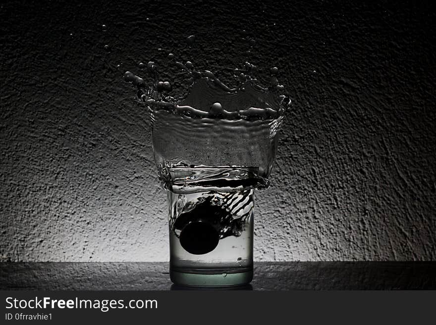 A glass of water with water splashing up.