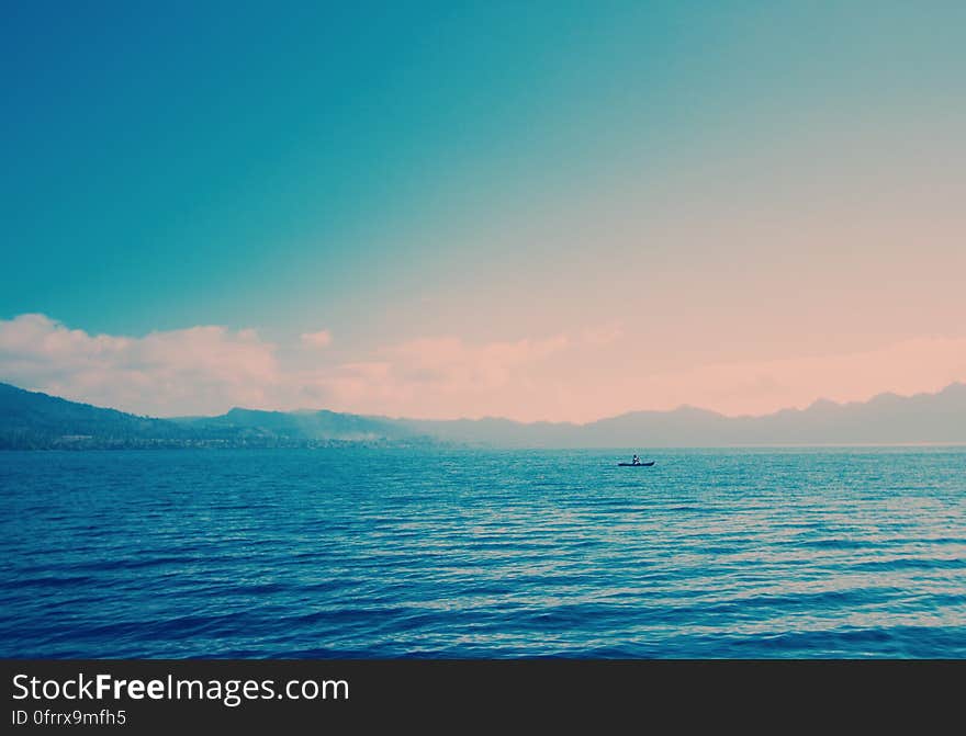 Sea and mountains in the horizon in toned color image.