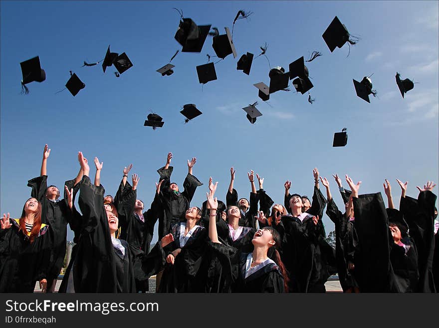 Fresh graduates throwing their mortarboards up in the air. Fresh graduates throwing their mortarboards up in the air.