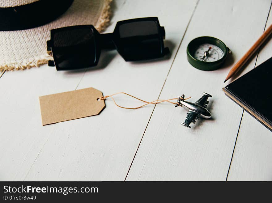 A background with holiday and travel accessories and a miniature airplane with an empty label. A background with holiday and travel accessories and a miniature airplane with an empty label.