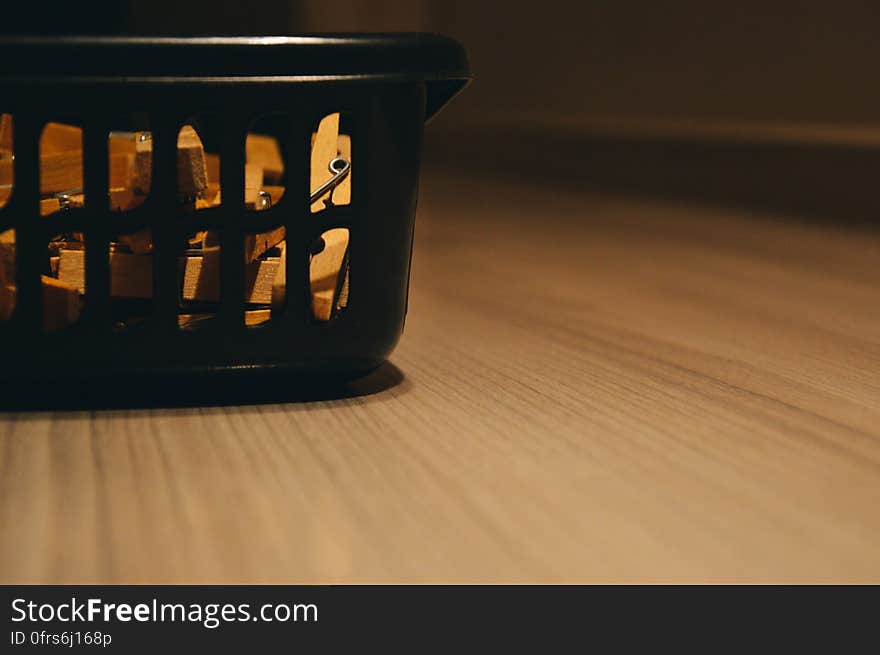 Washing basket with lighting effect on wooden laminate floor in home. Washing basket with lighting effect on wooden laminate floor in home.