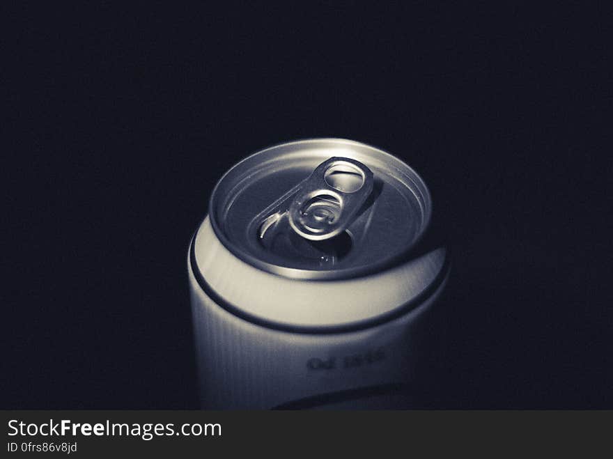 Closeup of the top of an aluminium drinks can showing the pull tab (mechanism) used to open the can, black background. Closeup of the top of an aluminium drinks can showing the pull tab (mechanism) used to open the can, black background.