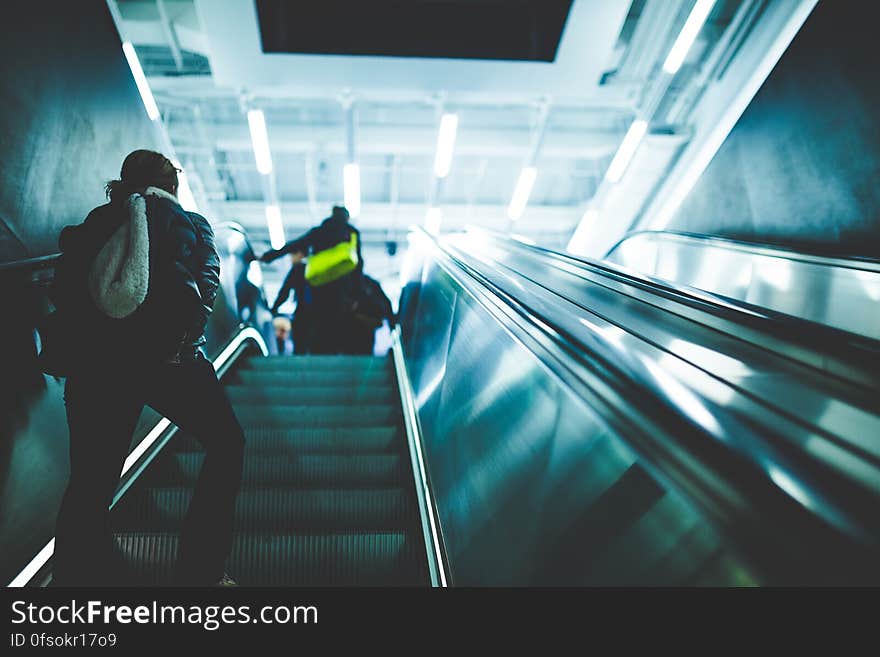 Person Riding on Escalator