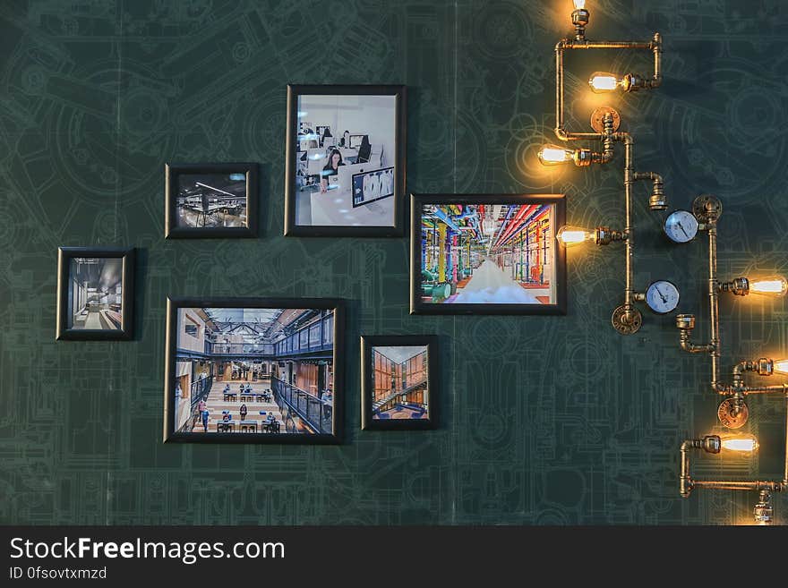 A wall with framed pictures and retro lighting. A wall with framed pictures and retro lighting.