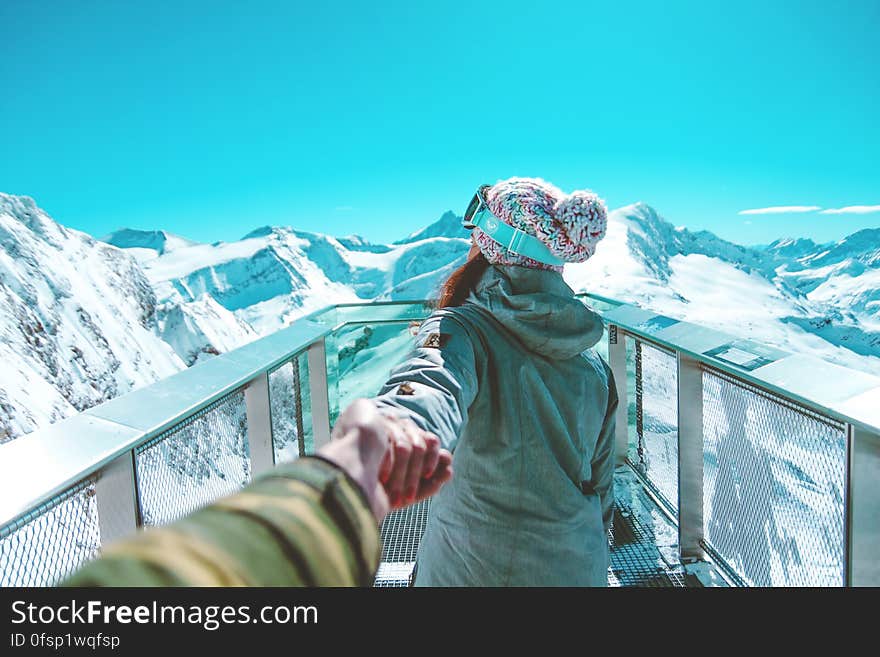 A woman leading a man off into the mountains. A woman leading a man off into the mountains.