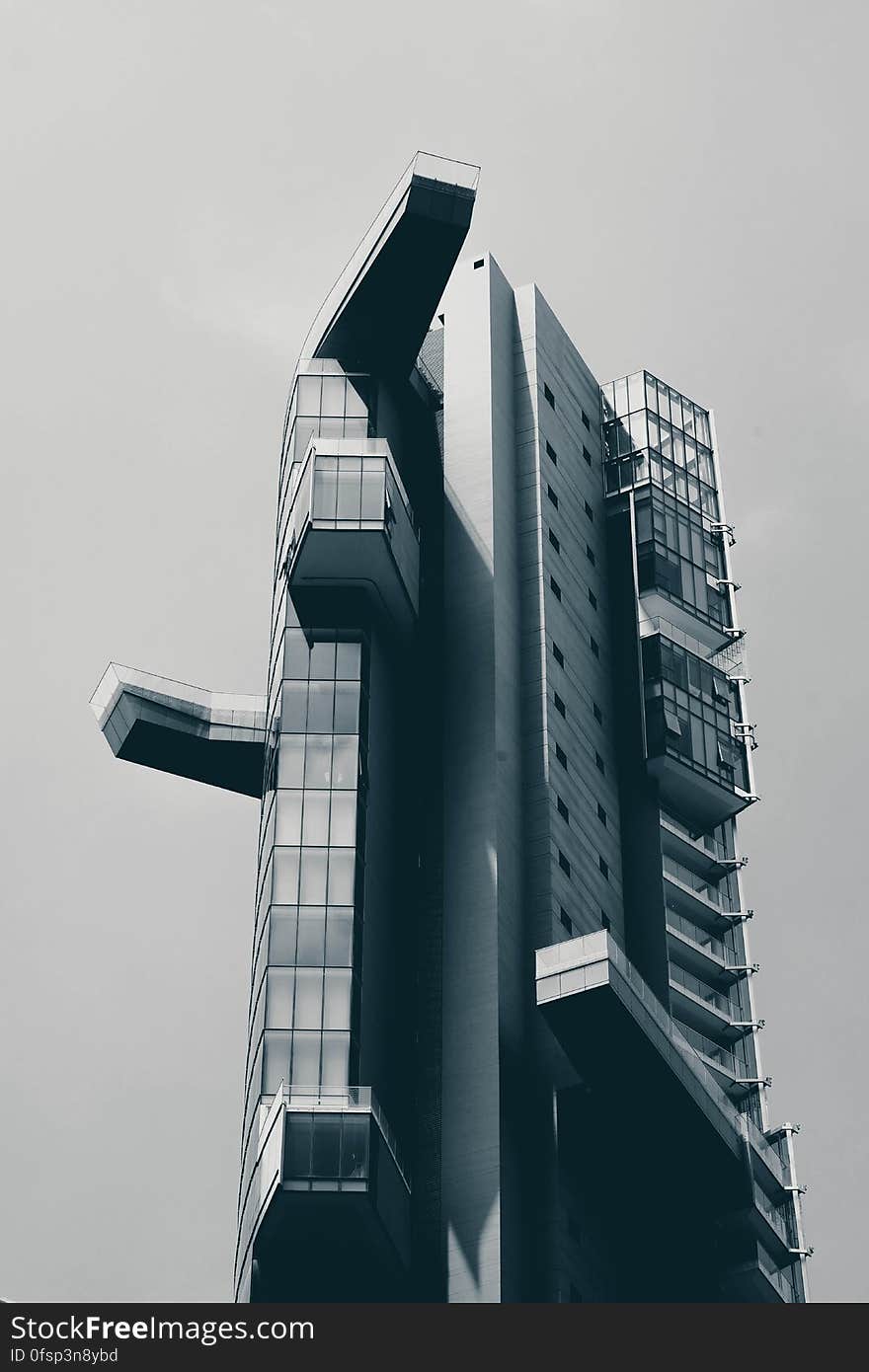 A black and white photo of a modern high rise building from a low angle.