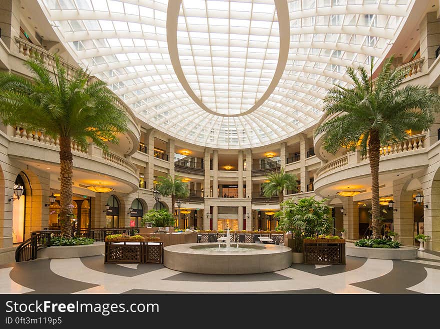 Fountain in center or contemporary lobby of modern mall with sunlight. Fountain in center or contemporary lobby of modern mall with sunlight.