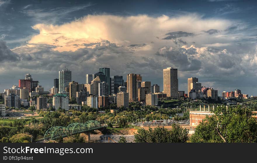 City skyline with modern skyscrapers against cloudy skies at sunset. City skyline with modern skyscrapers against cloudy skies at sunset.