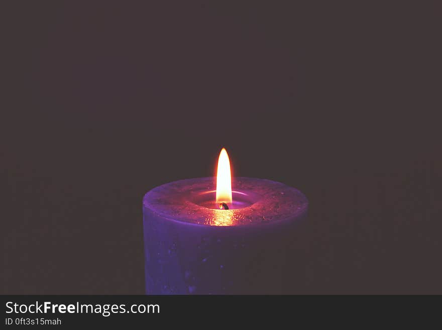 Purple candle with burning wick with copy space. Purple candle with burning wick with copy space.