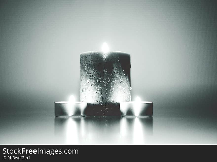 Monochrome view of group of large and small burning candles. Monochrome view of group of large and small burning candles.