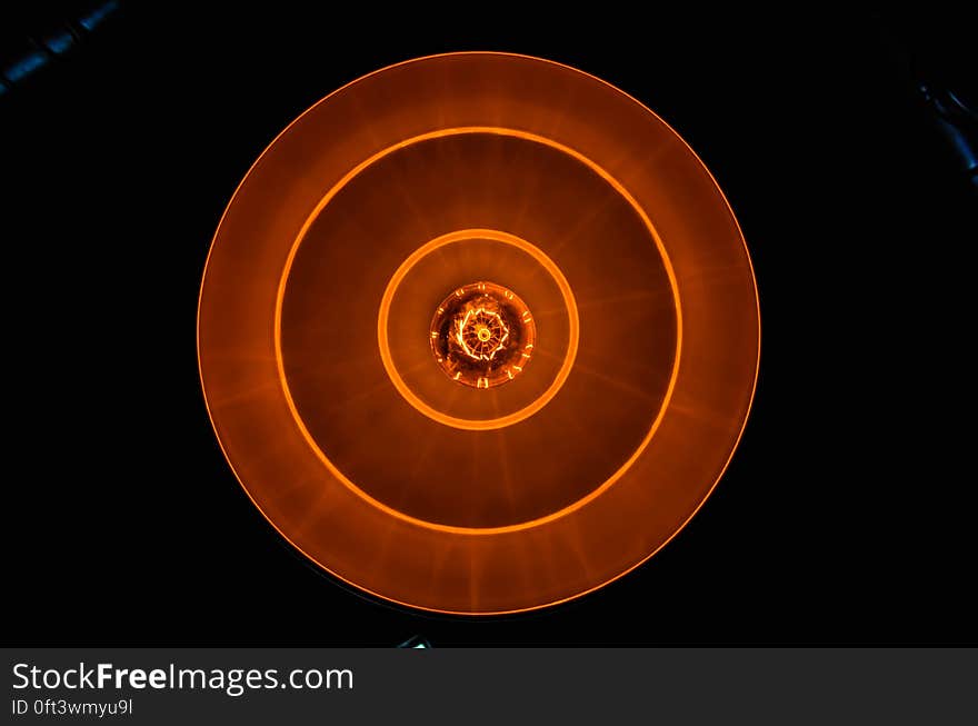 A close up of a burning lightbulb seen from above. A close up of a burning lightbulb seen from above.