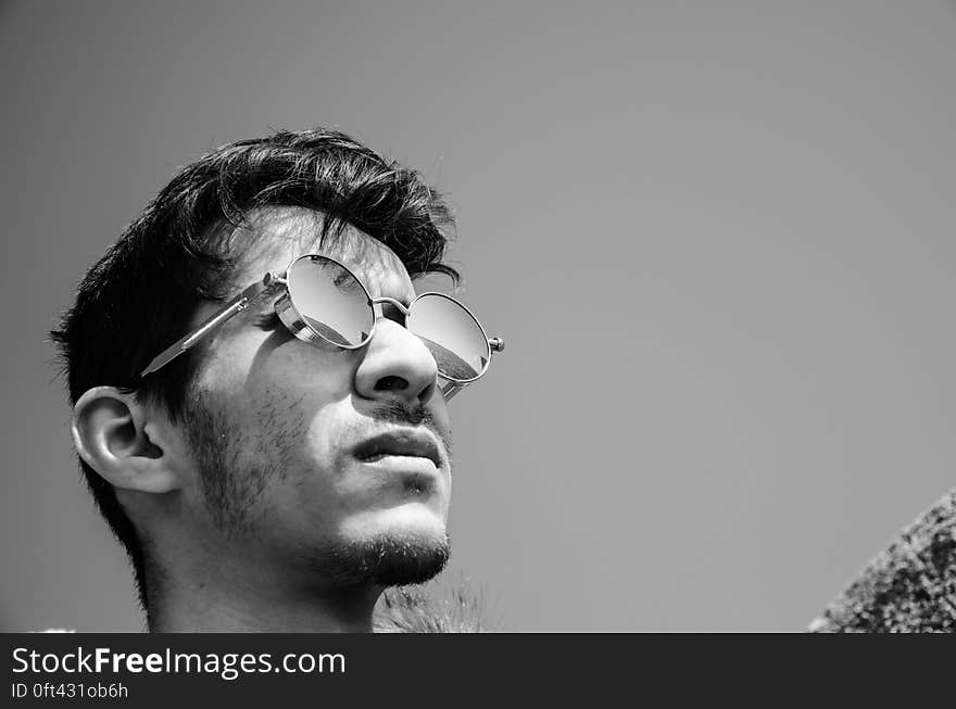 Profile of young man wearing sunglasses outdoors in black and white. Profile of young man wearing sunglasses outdoors in black and white.