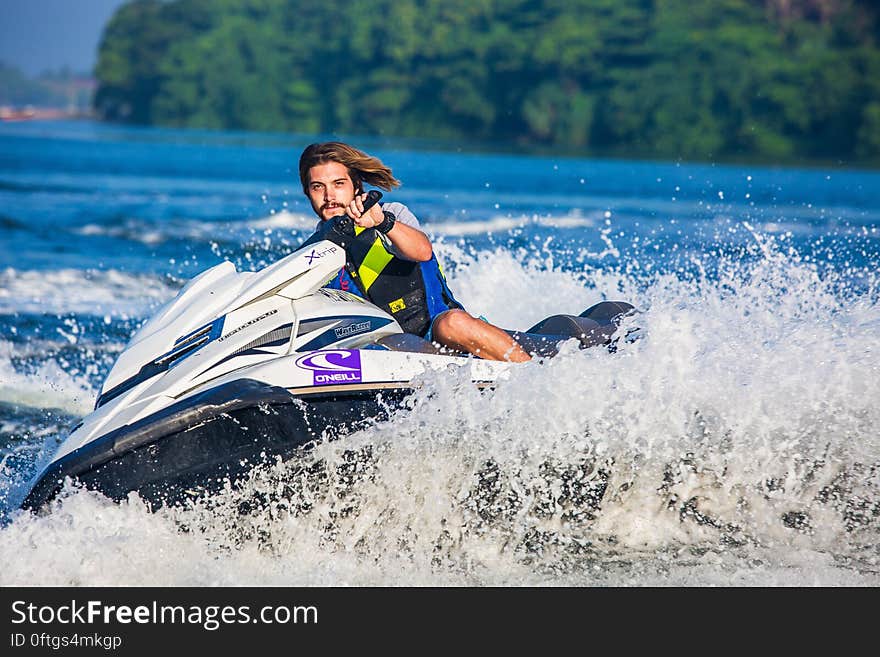 Man in Safety Vest Riding a Personal Watercraft during Daytime