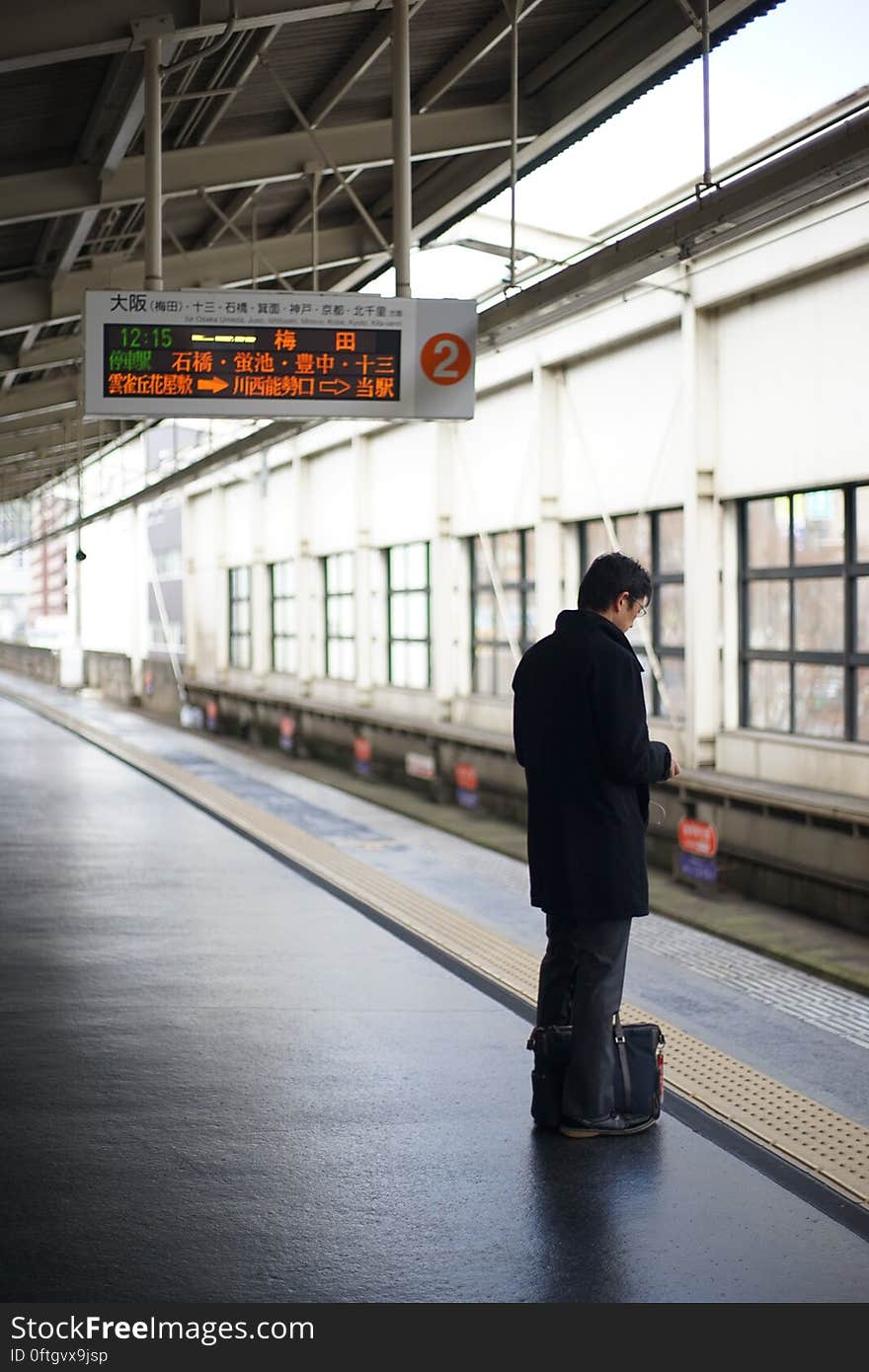 Man waiting on platform of Japanese subway station for train. Man waiting on platform of Japanese subway station for train.