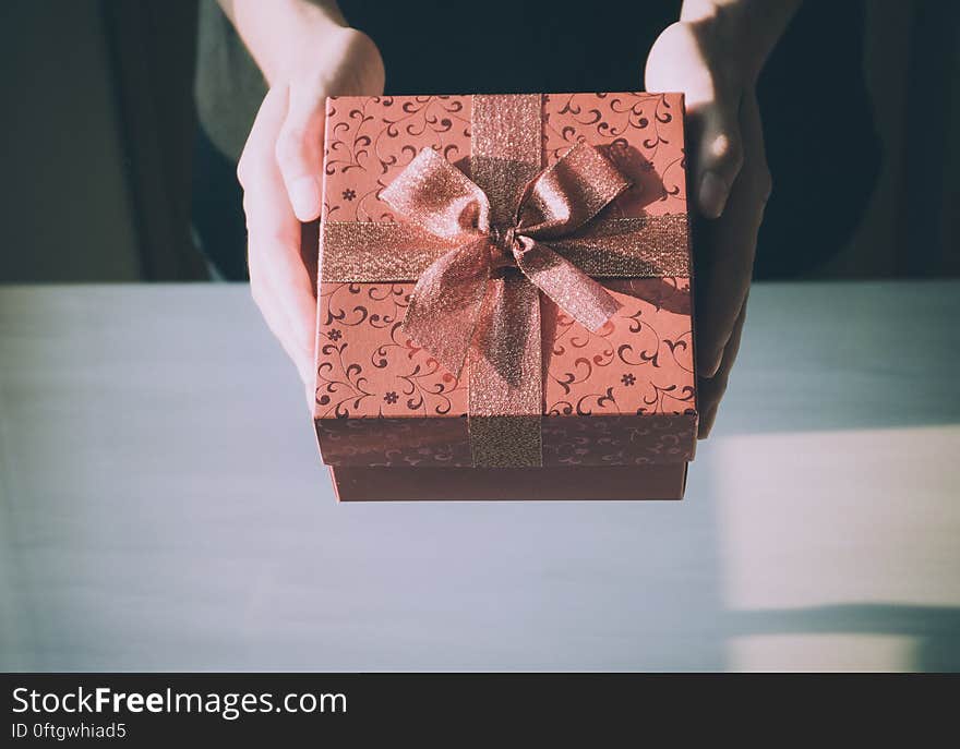 A person holding out a present. A person holding out a present.