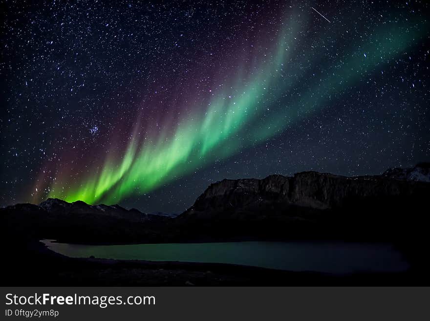 A starry sky over a lake with aurora on the sky. A starry sky over a lake with aurora on the sky.