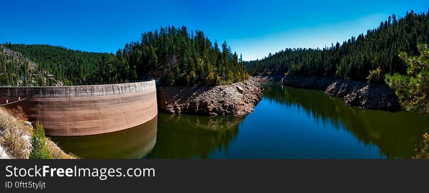 Craigin Dam and Reservoir with clear water, rocks and forest surroundings, cloudless blue sky. Craigin Dam and Reservoir with clear water, rocks and forest surroundings, cloudless blue sky.