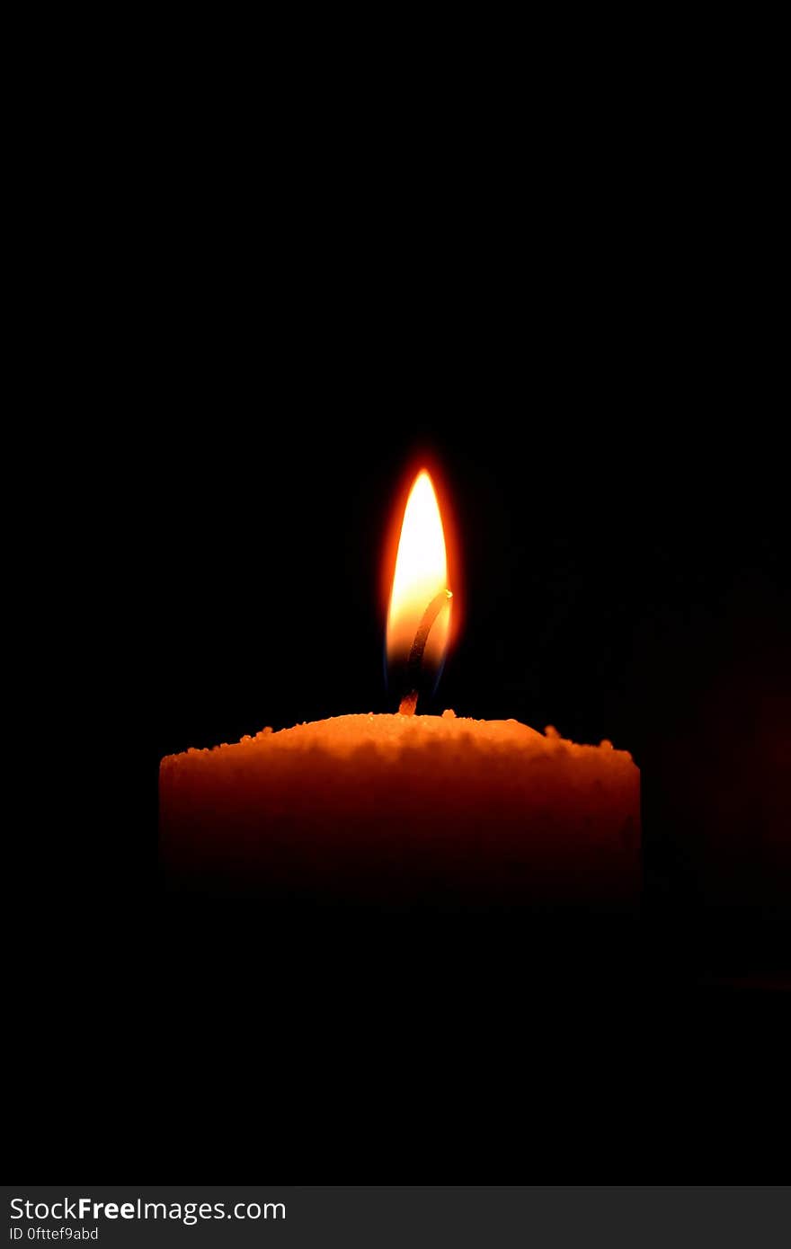 A close up of a candle burning in the dark. A close up of a candle burning in the dark.