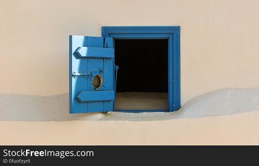 Open blue wooden door on outside of sandy wall. Open blue wooden door on outside of sandy wall.