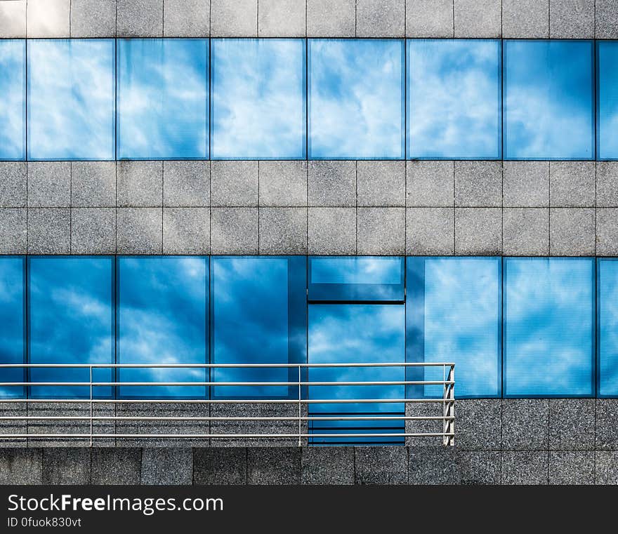 The exterior of a building with sky reflecting from the windows. The exterior of a building with sky reflecting from the windows.