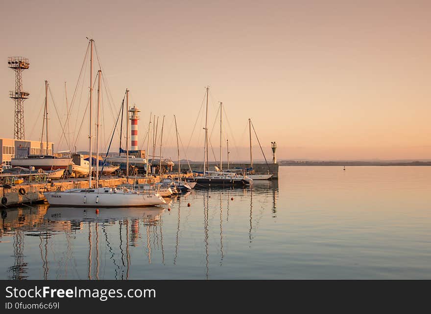 A sunset over a dock with ships and boats docked in. A sunset over a dock with ships and boats docked in.