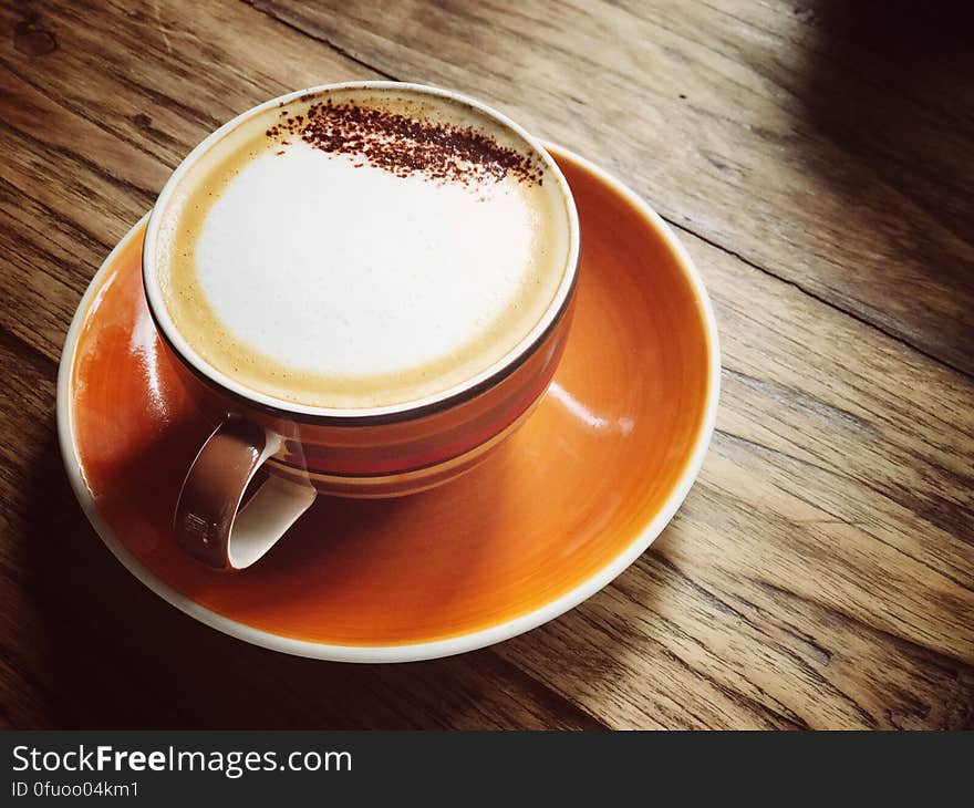 A cup of cappuccino with milk foam and cocoa powder on top. A cup of cappuccino with milk foam and cocoa powder on top.