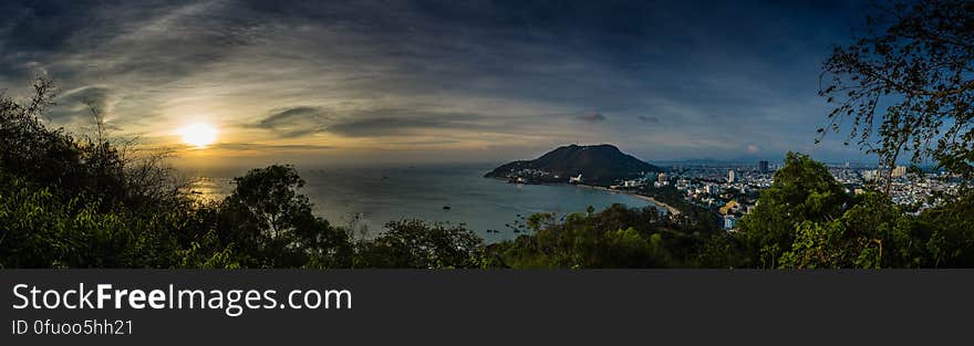 A panorama over a city and cape in the sea at sunset. A panorama over a city and cape in the sea at sunset.