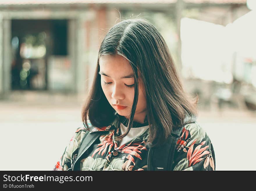 A pensive Asian girl out on the street.