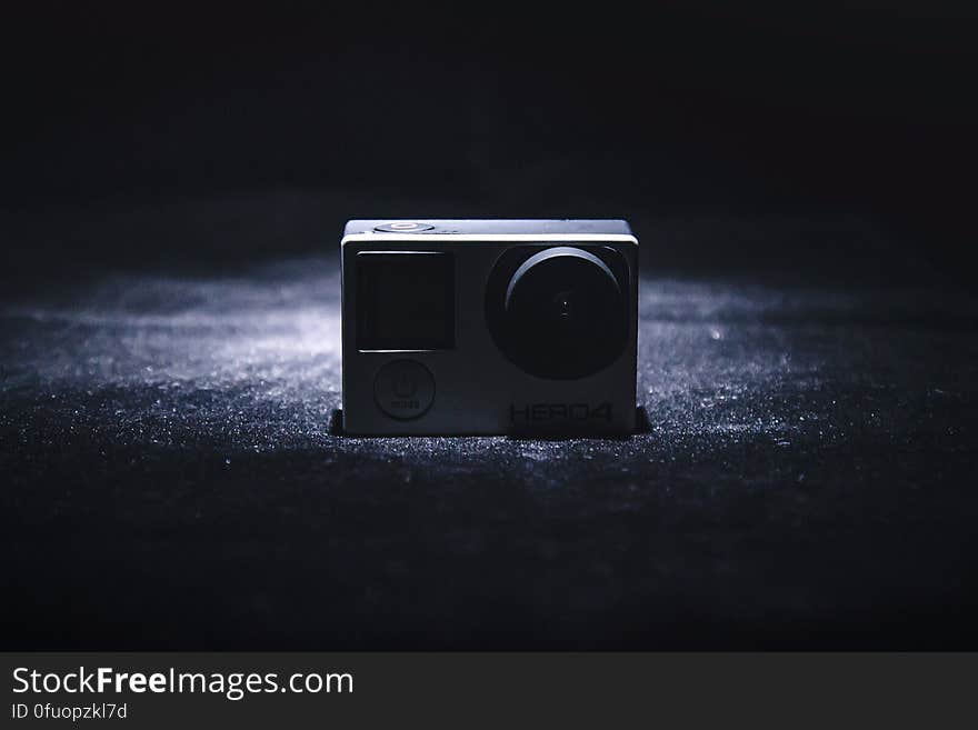 Close up of small GoPro camera on black fabric in shadows. Close up of small GoPro camera on black fabric in shadows.