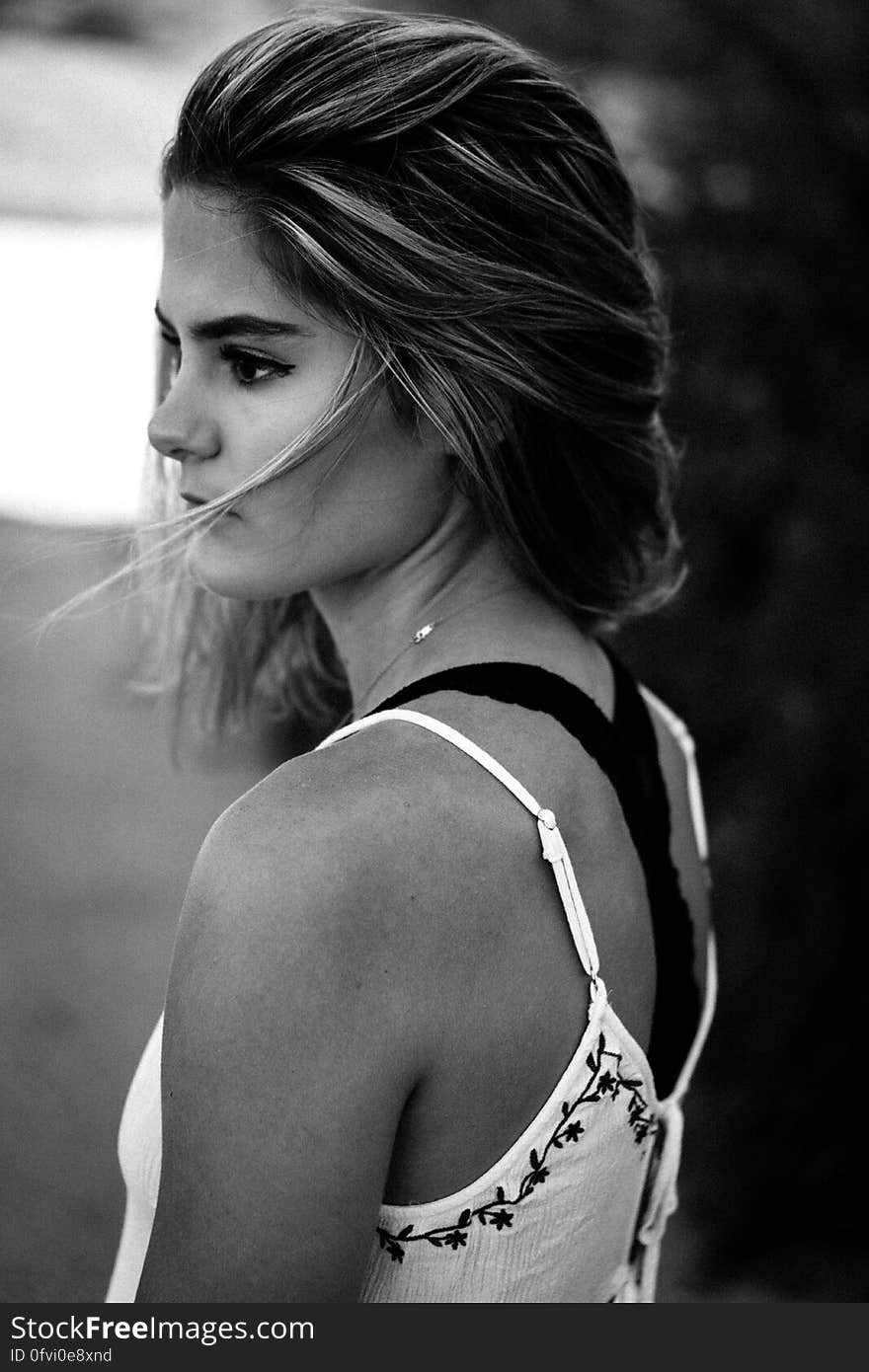 Portrait of young woman with serious expression standing outdoors in black and white. Portrait of young woman with serious expression standing outdoors in black and white.