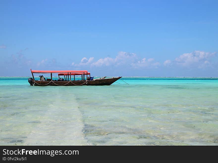 People on Black Boat Under Blue Sky at Daytime