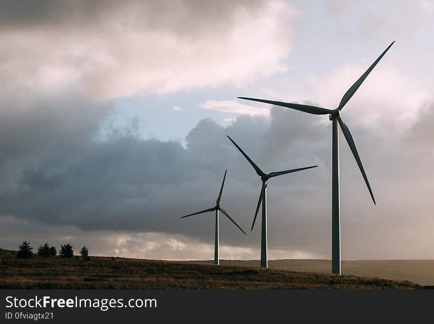 Modern windmills rotating in a field. Modern windmills rotating in a field.