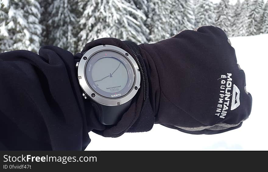 A man in the winter forest wearing a sports and activity tracking watch with GPS. A man in the winter forest wearing a sports and activity tracking watch with GPS.