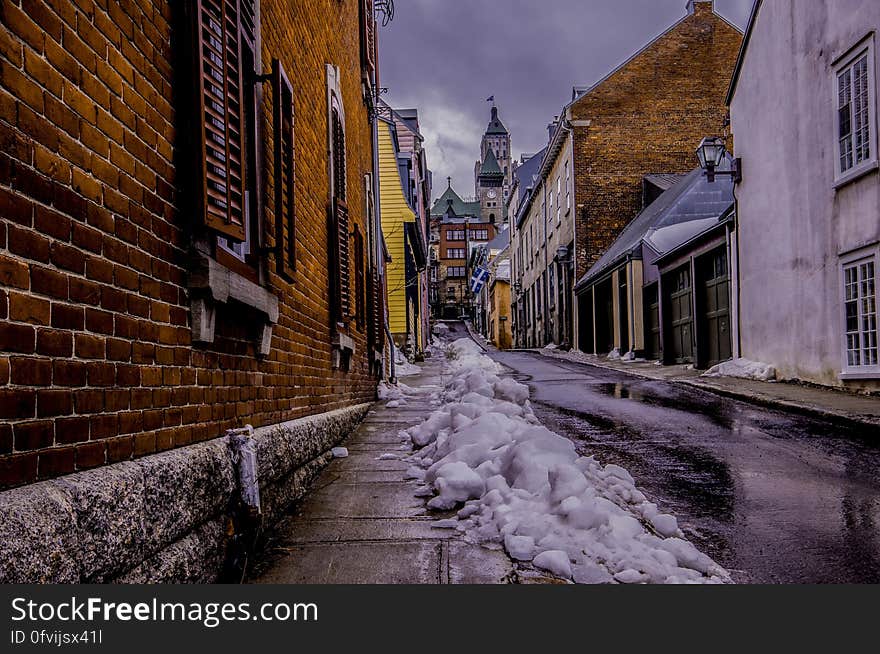 An alleyway in the city in the winter with snow collected on the sidewalk. An alleyway in the city in the winter with snow collected on the sidewalk.